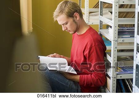 young male student reading textbook in school library View Large Photo Image Stock Image - young male student reading textbook in school library. Fotosearch