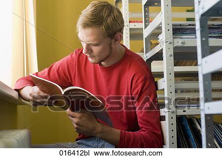 young male student reading textbook in school library View Large Photo Image Stock Image - young male student reading textbook in school library. Fotosearch