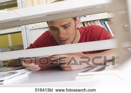 young male student reading textbook in school library View Large Photo Image Stock Image - young male student reading textbook in school library. Fotosearch