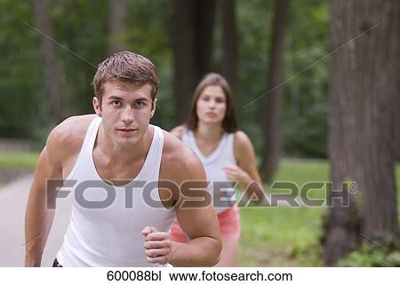 young man and woman jogging through park View Large Photo Image Stock Image - young man and woman jogging through park. Fotosearch