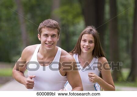 young man and woman jogging through park View Large Photo Image Stock Image - young man and woman jogging through park. Fotosearch