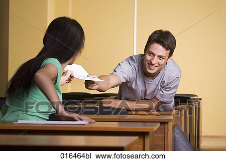 young man giving document to female student during school seminar View Large Photo Image Stock Image - young man giving document to female student during school seminar. Fotosearch