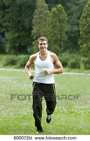 young man jogging through park and listening to music View Large Photo Image Stock Image - young man jogging through park and listening to music. Fotosearch