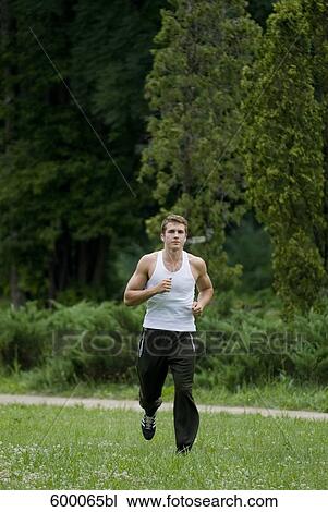 young man jogging through park View Large Photo Image Stock Image - young man jogging through park. Fotosearch