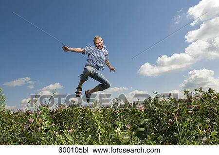 young man jumping in summer meadow View Large Photo Image Stock Image - young man jumping in summer meadow. Fotosearch