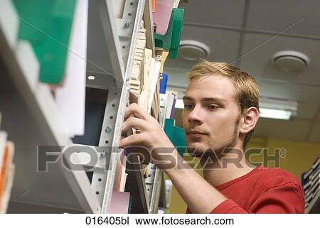young student in library taking book from shelf View Large Photo Image Stock Image - young student in library taking book from shelf. Fotosearch