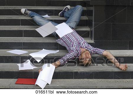 young student lying on his back on stairs surrounded by school documents View Large Photo Image Stock Image - young student lying on his back on stairs surrounded by school documents. Fotosearch