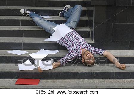 young student lying on his back on stairs surrounded by school documents View Large Photo Image Stock Image - young student lying on his back on stairs surrounded by school documents. Fotosearch