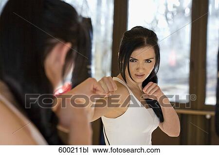 young woman doing kickboxing exercise in front of mirror View Large Photo Image Stock Image - young woman doing kickboxing exercise in front of mirror. Fotosearch
