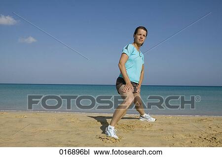young woman doing stretching exercises on beach View Large Photo Image Stock Image - young woman doing stretching exercises on beach. Fotosearch