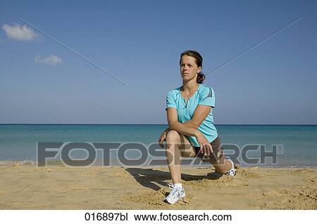 young woman doing stretching exercises on beach View Large Photo Image Stock Image - young woman doing stretching exercises on beach. Fotosearch
