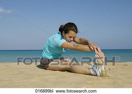 young woman doing stretching exercises on beach View Large Photo Image Stock Image - young woman doing stretching exercises on beach. Fotosearch