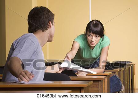 young woman giving document to male student during school seminar View Large Photo Image Stock Image - young woman giving document to male student during school seminar . Fotosearch