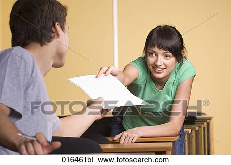 young woman giving document to male student during school seminar View Large Photo Image Stock Image - young woman giving document to male student during school seminar . Fotosearch