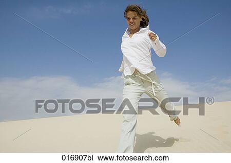 young woman running on sandy beach View Large Photo Image Stock Image - young woman running on sandy beach. Fotosearch