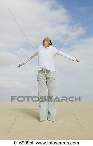 young woman standing on beach with outstretched arms View Large Photo Image Stock Image - young woman standing on beach with outstretched arms. Fotosearch
