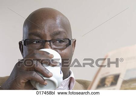black businessman reading newspaper and drinking coffe View Large Photo Image Stock Image - black businessman reading newspaper and drinking coffe. Fotosearch