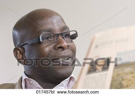 Stock Image - black businessman reading newspaper. Fotosearch