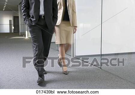 businessman and businesswoman walking together through empty office floor View Large Photo Image Stock Image - businessman and businesswoman walking together through empty office floor. Fotosearch