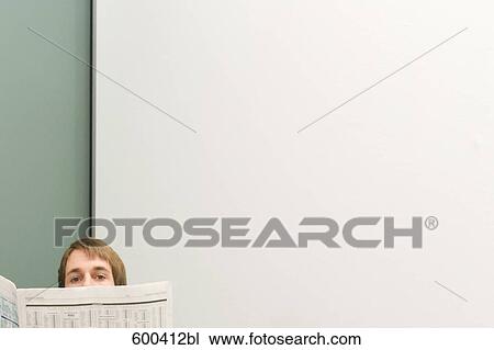 Stock Image - businessman peeking from behind newspaper. Fotosearch
