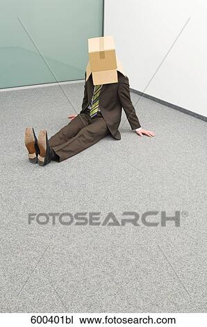Stock Image - businessman sitting in corner with cardboard box over his head. Fotosearch