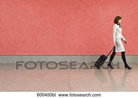 businesswoman in corridor pulling carry-on suitcase View Large Photo Image Stock Image - businesswoman in corridor pulling carry-on suitcase. Fotosearch