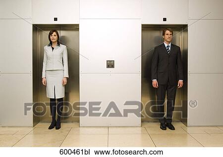 businesswoman standing side by side with male colleague in elevator doors View Large Photo Image Stock Image - businesswoman standing side by side with male colleague in elevator doors. Fotosearch
