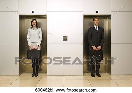 businesswoman standing side by side with male colleague in elevator doors View Large Photo Image Stock Image - businesswoman standing side by side with male colleague in elevator doors. Fotosearch