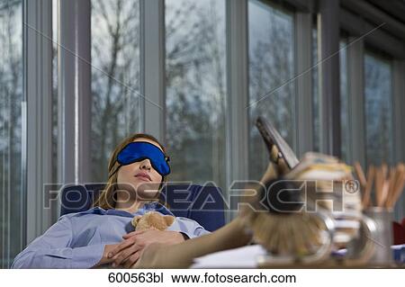 businesswoman taking a nap at her desk wearing sleep mask View Large Photo Image Stock Image - businesswoman taking a nap at her desk wearing sleep mask. Fotosearch