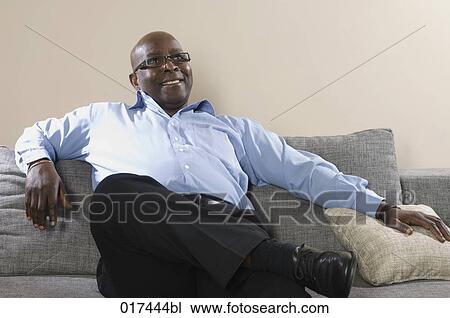 content black businessman sitting on sofa View Large Photo Image Stock Image - content black businessman sitting on sofa. Fotosearch
