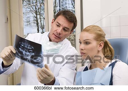 dentist showing female patient x-ray of her teeth View Large Photo Image Stock Image - dentist showing female patient x-ray of her teeth . Fotosearch
