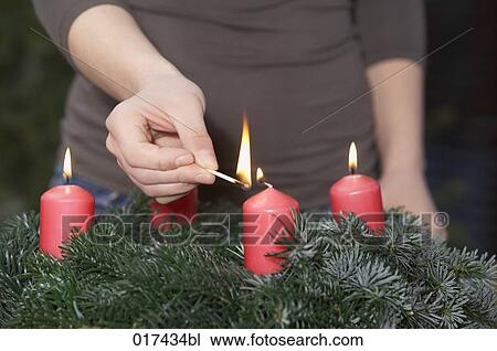 Stock Image - detail of woman lighting advent wreath. Fotosearch