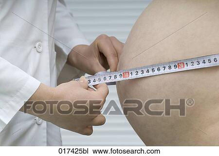 Stock Image - doctor measuring belly of pregnant woman. Fotosearch