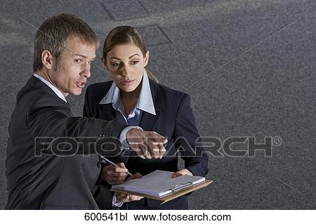 executive talking to female colleague pointing direction View Large Photo Image Stock Image - executive talking to female colleague pointing direction. Fotosearch