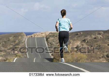 full body portrait of woman jogging along empty road View Large Photo Image Stock Image - full body portrait of woman jogging along empty road. Fotosearch
