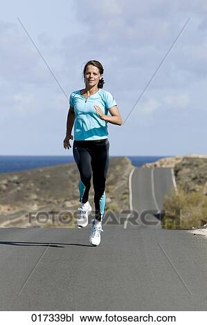 full body portrait of woman jogging along empty road View Large Photo Image Stock Image - full body portrait of woman jogging along empty road. Fotosearch