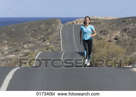 full body portrait of woman jogging along empty road View Large Photo Image Stock Image - full body portrait of woman jogging along empty road. Fotosearch