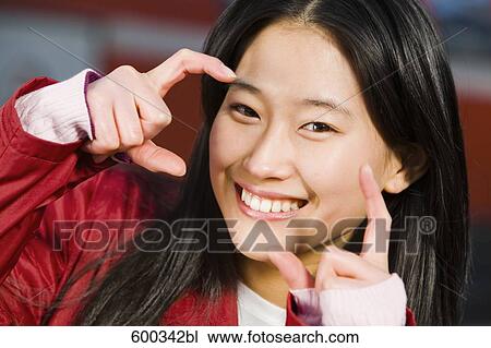 headshot of japanese woman doing the gesture of photographing View Large Photo Image Stock Image - headshot of japanese woman doing the gesture of photographing. Fotosearch