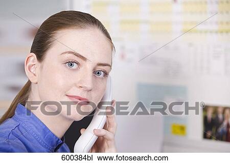 Stock Image - headshot of nurse talking on telephone. Fotosearch