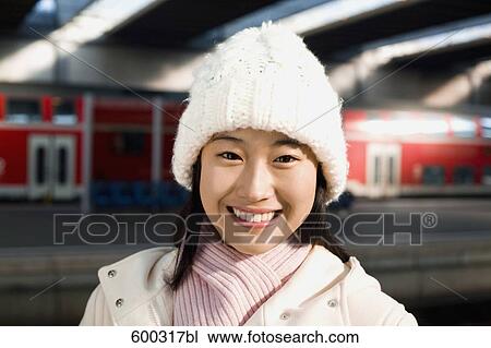 Stock Image - headshot of young japanese woman at train station. Fotosearch