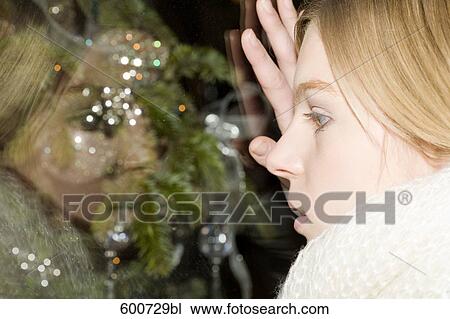 headshot of young woman looking through shop window with christmas decoration View Large Photo Image Stock Image - headshot of young woman looking through shop window with christmas decoration. Fotosearch