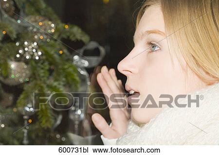 headshot of young woman looking through shop window with christmas decoration View Large Photo Image Stock Image - headshot of young woman looking through shop window with christmas decoration. Fotosearch