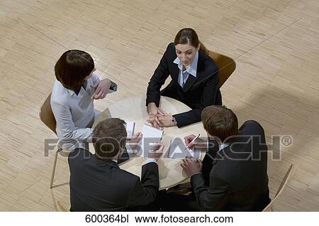 high angle view of four business people sitting around conference table View Large Photo Image Stock Image - high angle view of four business people sitting around conference table. Fotosearch