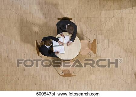 high angle view of group of business people sitting around conference table View Large Photo Image Stock Image - high angle view of group of business people sitting around conference table. Fotosearch