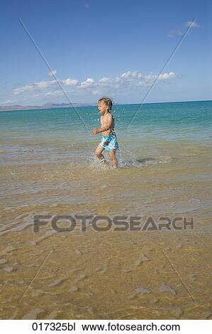 little girl walking through surf on beach View Large Photo Image Stock Image - little girl walking through surf on beach. Fotosearch