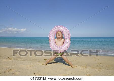 little girl with floating tyre on beach View Large Photo Image Stock Image - little girl with floating tyre on beach. Fotosearch