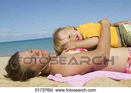 mother and little son relaxing on sandy beach View Large Photo Image Stock Image - mother and little son relaxing on sandy beach. Fotosearch