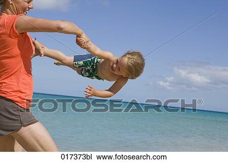 mother playing with her young daughter on beach View Large Photo Image Stock Image - mother playing with her young daughter on beach. Fotosearch