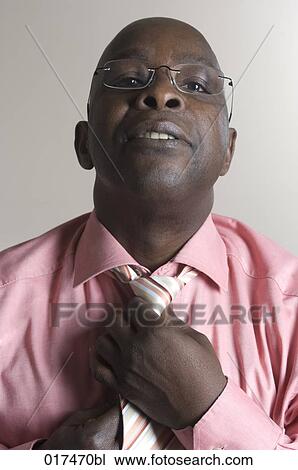 portrait of black businessman adjusting tie knot View Large Photo Image Stock Image - portrait of black businessman adjusting tie knot. Fotosearch