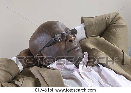 Stock Image - portrait of black businessman taking a nap. Fotosearch